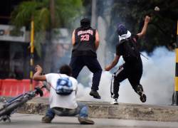 Manifestantes enfrentan a la policía durante una jornada de protestas en Cali (Colombia). Las protestas contra el Gobierno colombiano cumplen un mes con convocatorias a nuevas manifestaciones